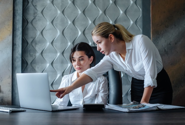 Free photo young business lady female director sitting at office desk using laptop computer working process business meeting working with colleague solving business tasks office collective concept