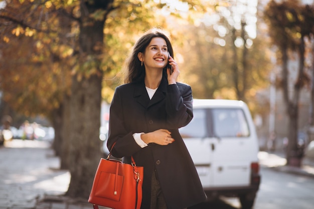 Young business lady using phone in the street