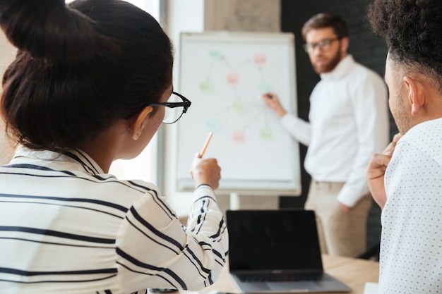 Free photo young business man showing project on desk