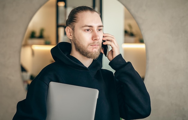 Free photo a young business man with a beard is talking on a smartphone