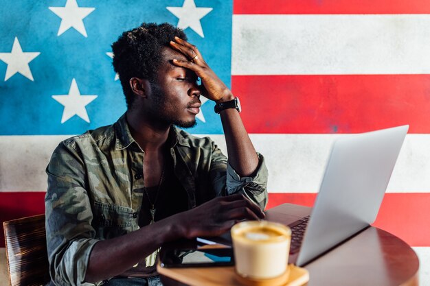 Young business man with a shocked expression working on a laptop.