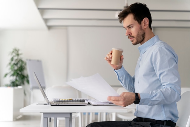 Free photo young business man working at her desk with laptop