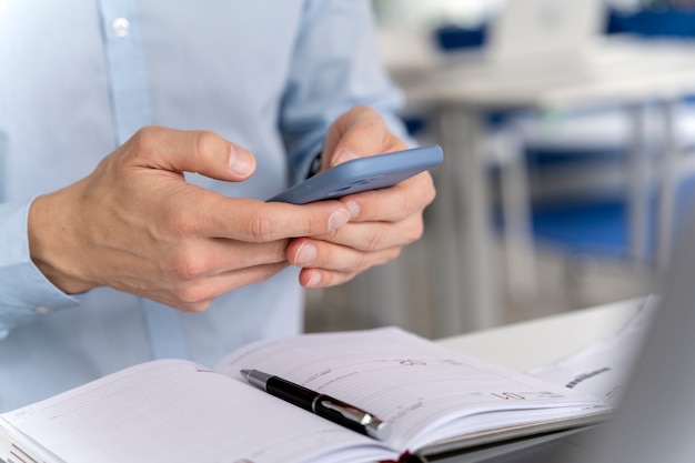 Young business man working at her desk with smartphone