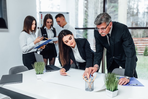 Young business people painting and writing at the modern office space.