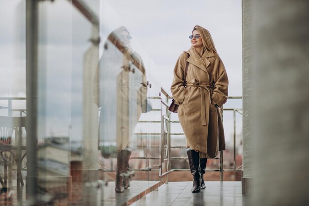 Young business woman in coat standing outside