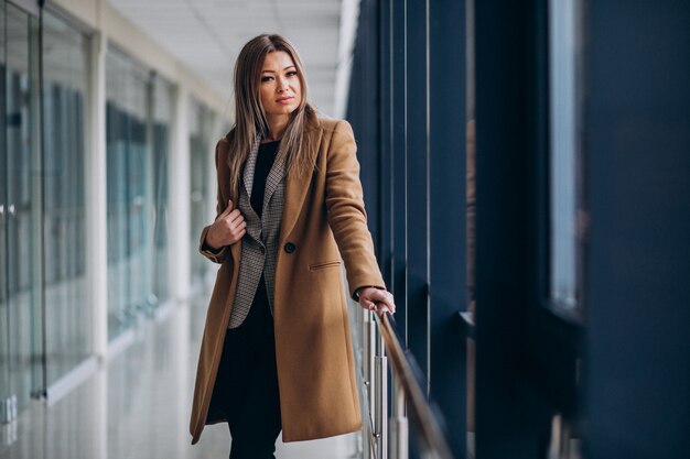 Young business woman in coat waiting in terminal