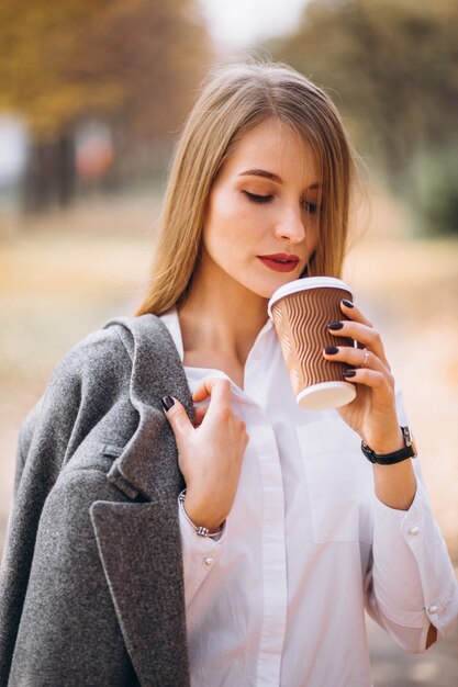 屋外でコーヒーを飲む若いビジネスの女性