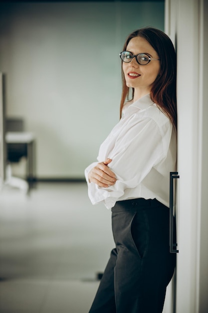 Young business woman in formal wear standing in office