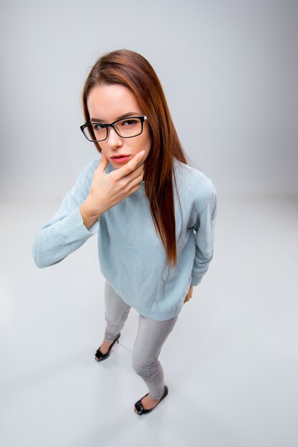 The young business woman in glasses on a gray background. Top view