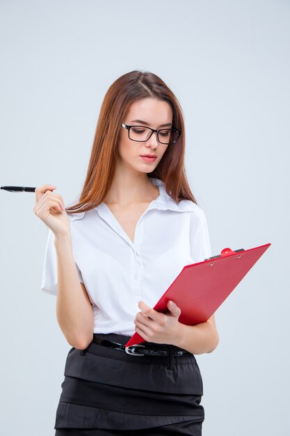 Young business woman in glasses with pen and clipboard