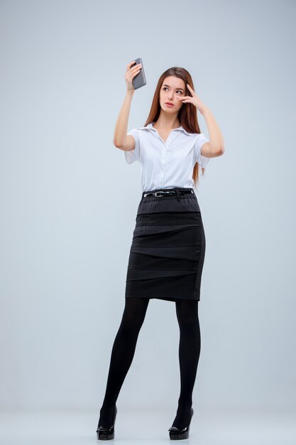 The young business woman on gray wall