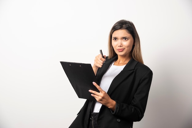 Young business woman holding clipboard .