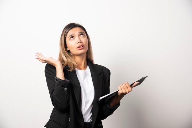 Young business woman holding clipboard . 