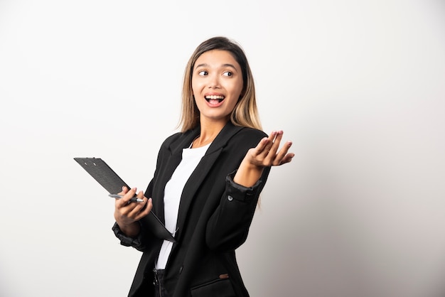 Young business woman holding clipboard . 