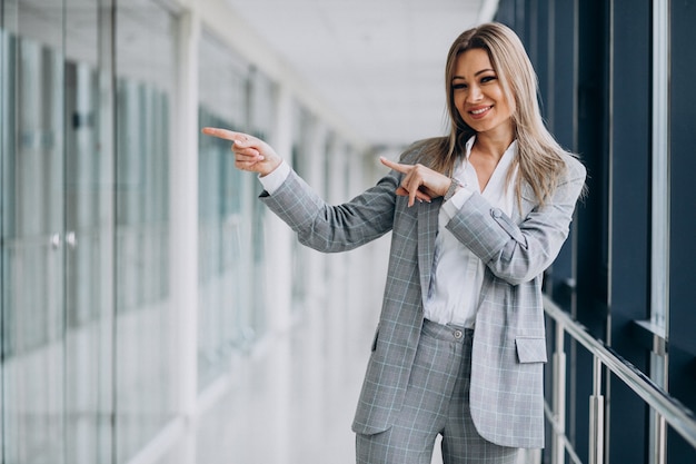 Free photo young business woman pointing, in an office