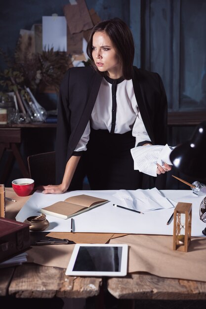 Young business woman scribbling documents. Disappointed and annoyed by unsuccessful project.