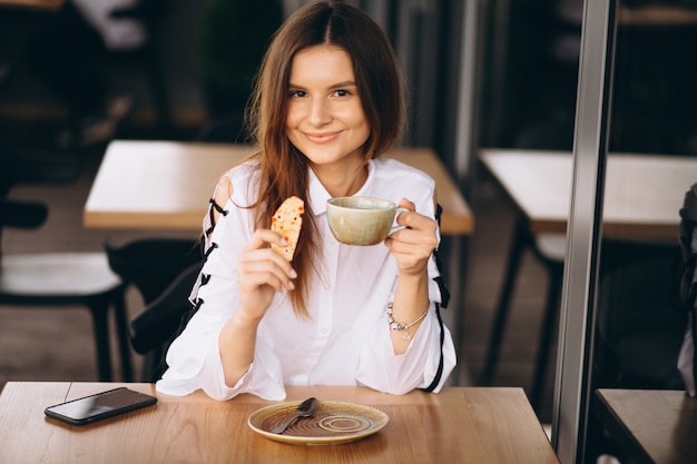 Young business woman sitting in a cafe with coffee and phone