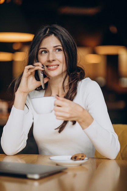 Young business woman sitting in a cahir and working on computer