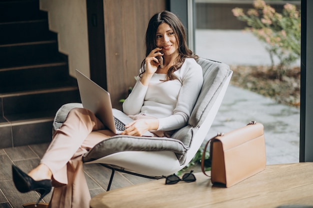 Young business woman sitting in a cahir and working on computer