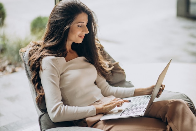 Young business woman sitting in a cahir and working on computer