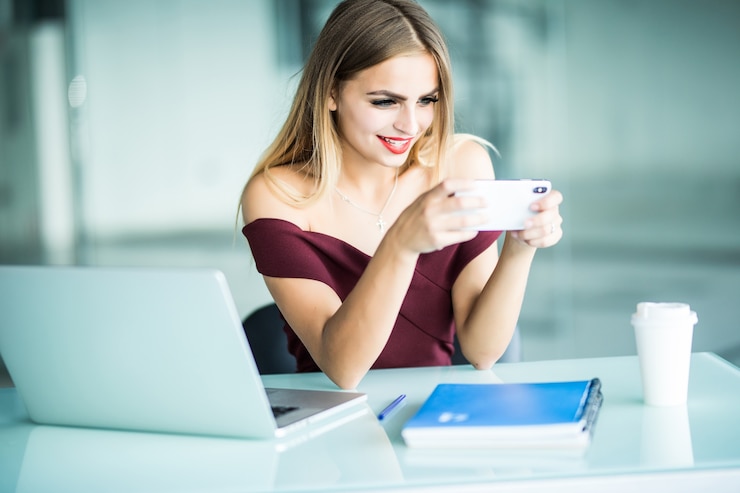 Free Photo young business woman sitting in office at table and using smartphone on desk is laptop. woman analyzing data. student learning online.