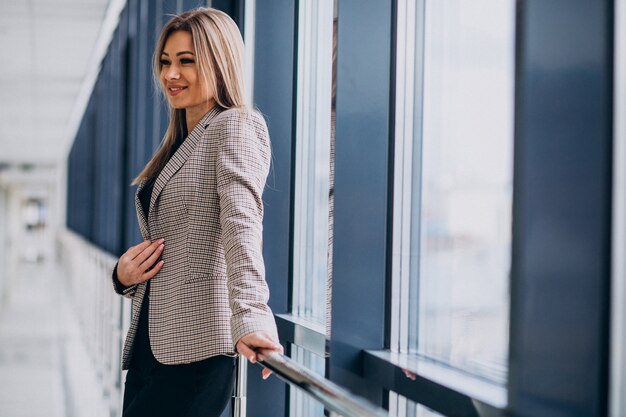 Young business woman standing by the window in an office