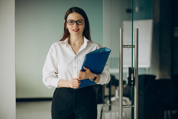 Young business woman standing at the office holding folder