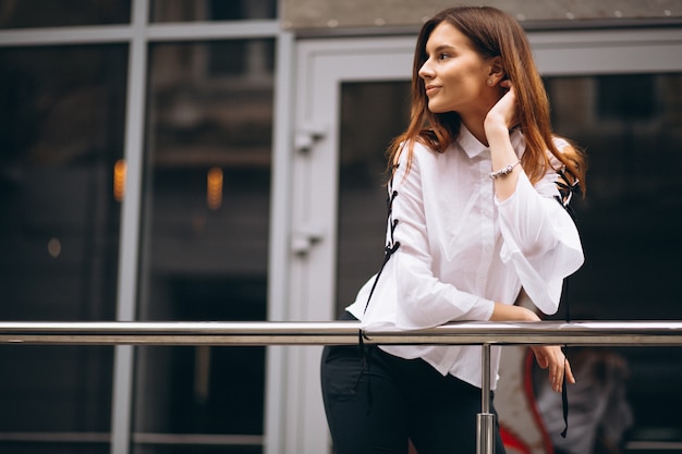 Free photo young business woman standing outside office center