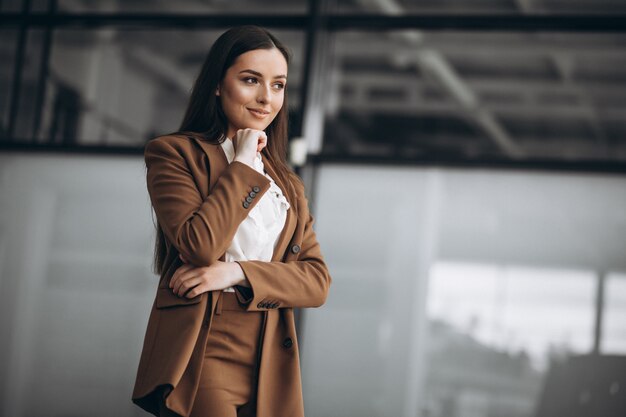 Young business woman standing in suit in office