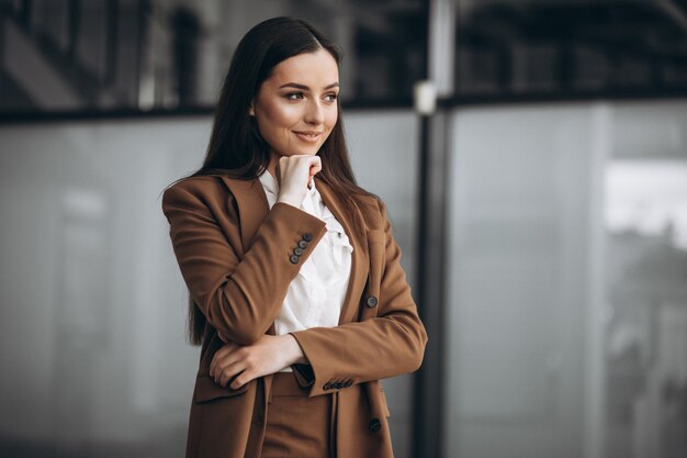 オフィスでスーツで立っている若いビジネス女性