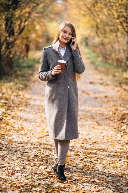 Young business woman talking on the phone and drinking coffee