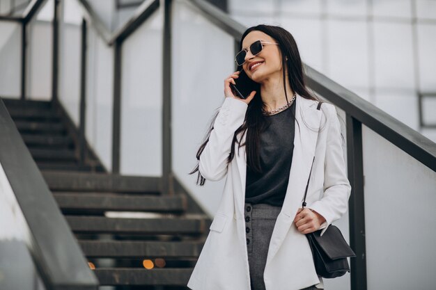 Young business woman talking on the phone in the street