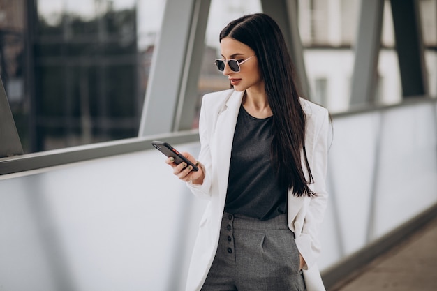 Free photo young business woman talking on the phone in the street