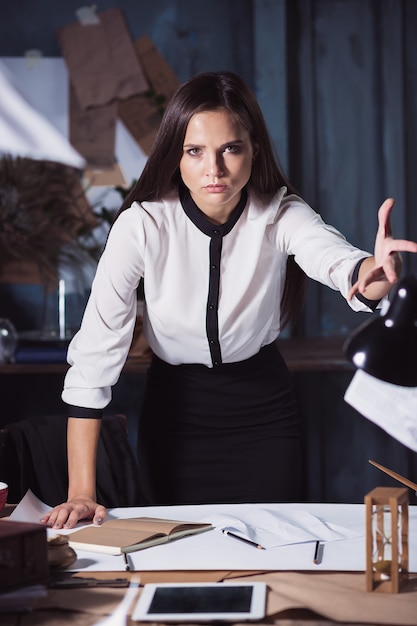 Young business woman throwing documents at camera. Disappointed and annoyed by unsuccessful project.
