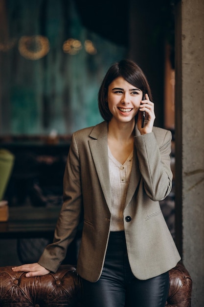 Giovane donna d'affari che utilizza il telefono in un caffè