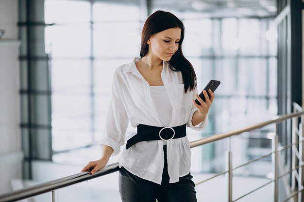 オフィスで電話を使用して若いビジネス女性