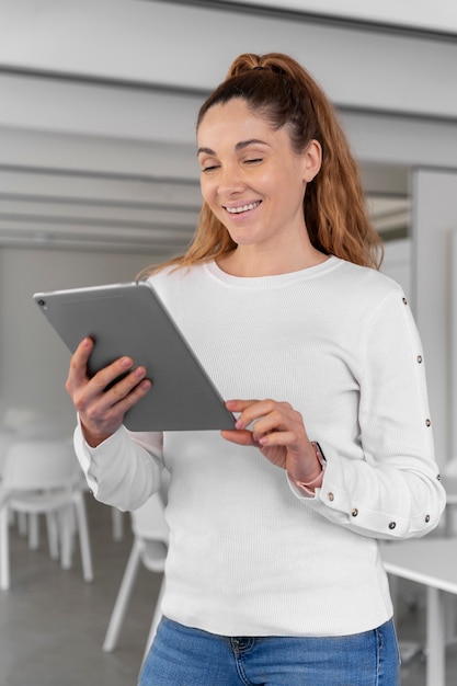 Free photo young business woman using tablet in the office