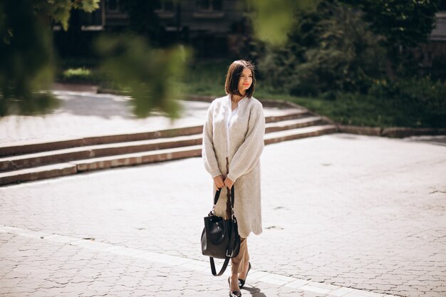 Young business woman walking in park