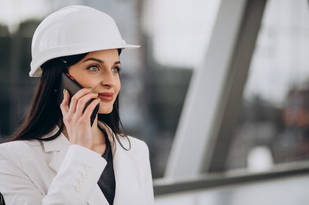 Young business woman wearing hard hat at building object
