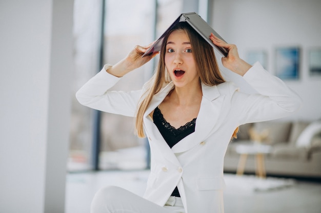 Giovane donna d'affari in abito bianco, lavorando su un computer