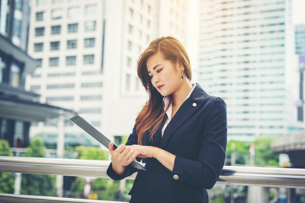 Young business woman with document in hand in front of building.