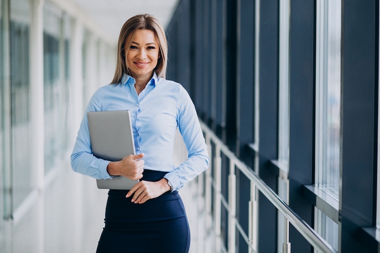 Free Photo young business woman with laptop standing in an office