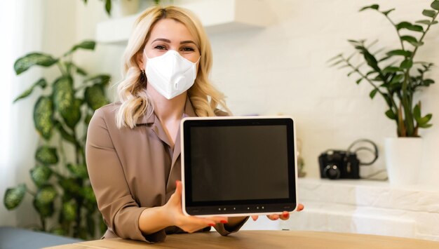 Young business woman working from home wearing protective mask.