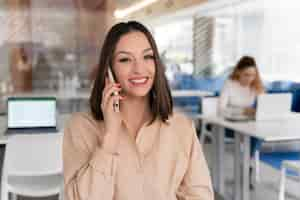 Free photo young business woman working at her desk with smartphone