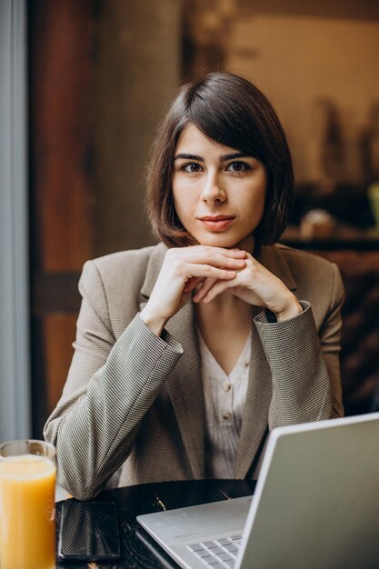 Young business woman working on laptop in a cafe