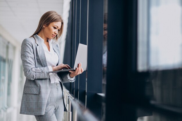 コンピューターのラップトップに取り組んでいる若いビジネス女性