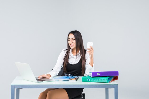 Young and business woman working in office isolated on white