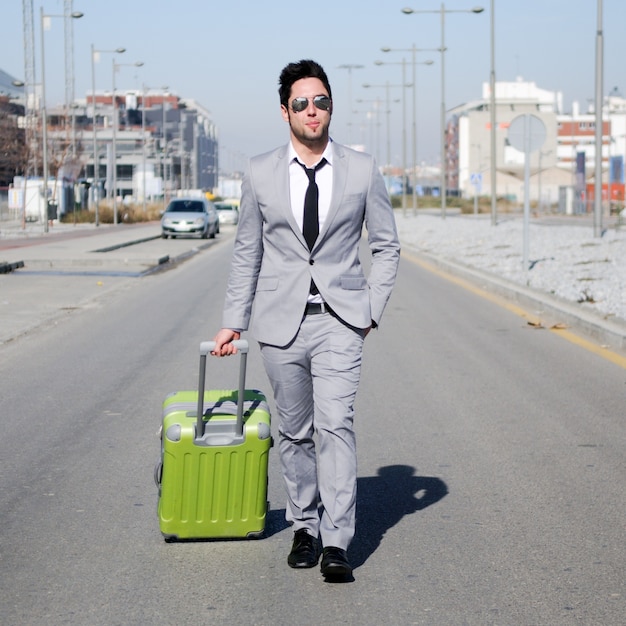 彼のスーツケースを運ぶ若いビジネスマン