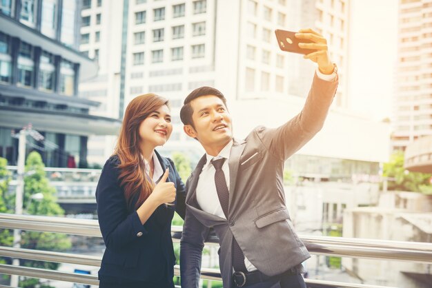 젊은 사업가 및 selfie 야외 도시 설정에서 selfie를 복용