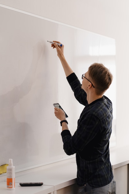 Young businessman discussing with colleagues over whiteboard at office